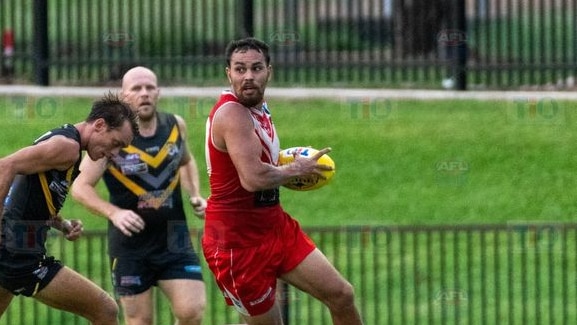 Indigenous man holding ball in football match 