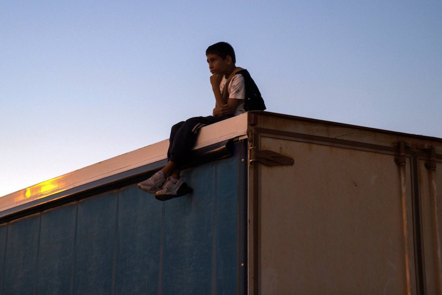 kid on truck roof in dark 