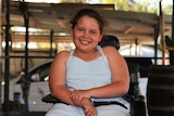 A photo of Katherine nine-year-old Felicity Brown in a wheelchair on the front deck of her house.