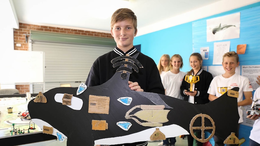 Boy holds cardboard cutout of an orca