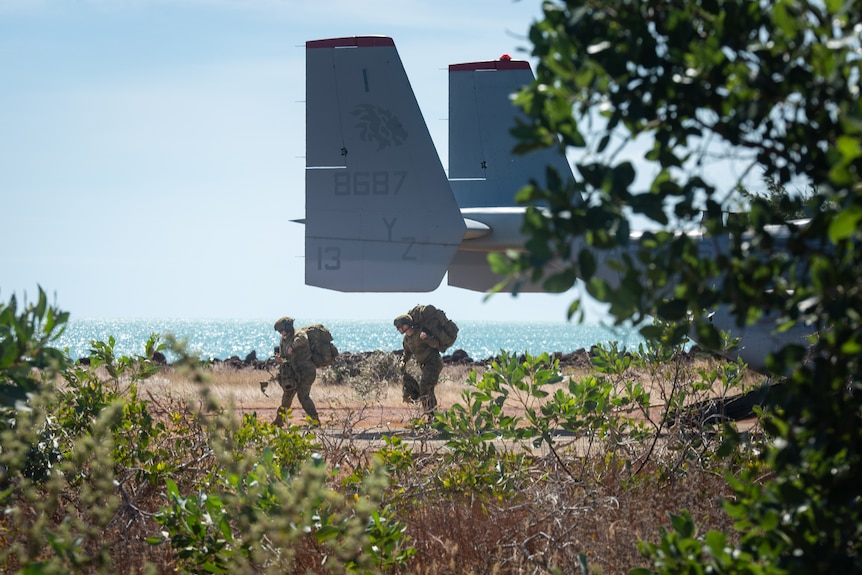 Two marines exit a plane on the Tiwi Islands