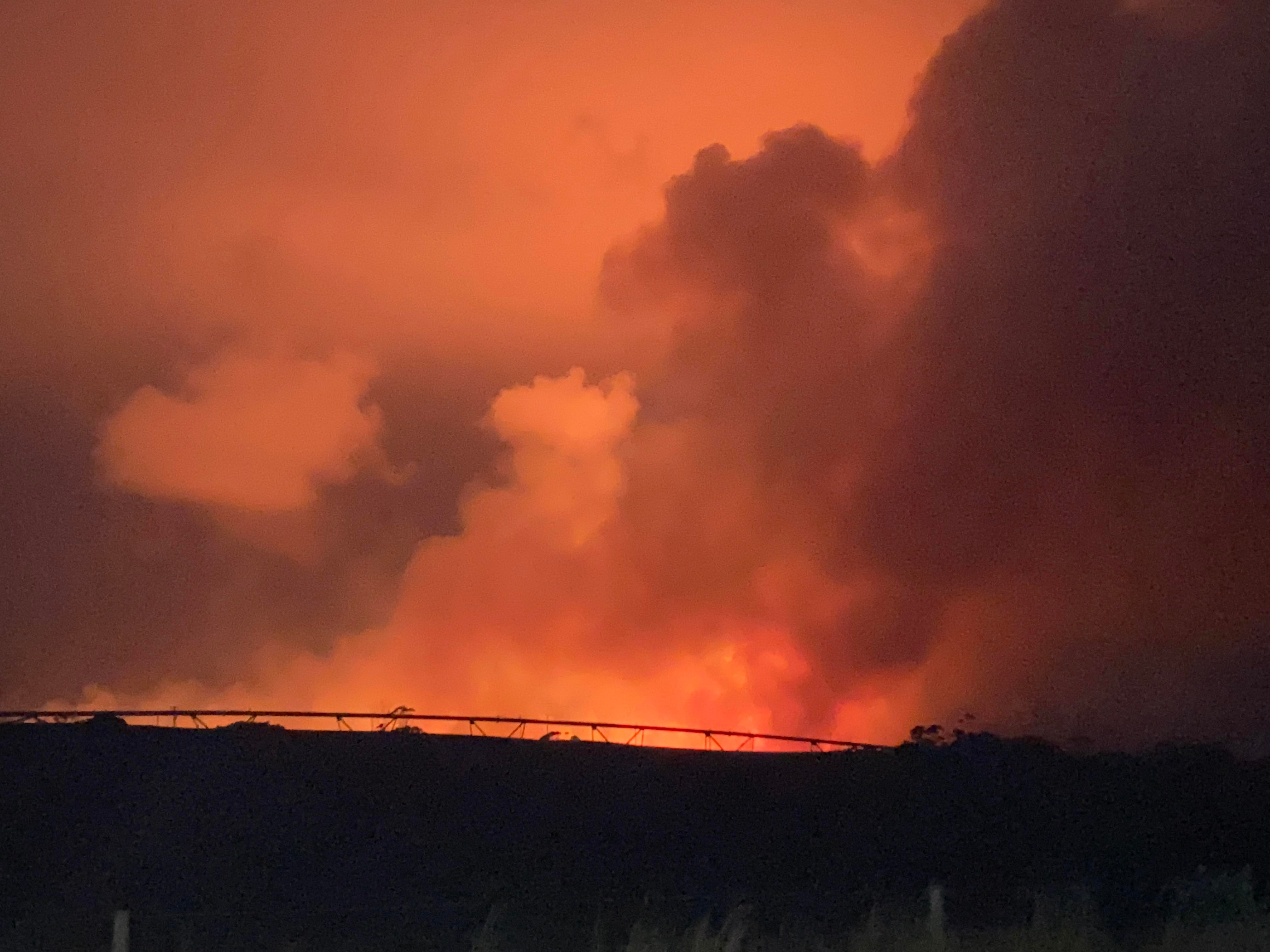 Smoke in an orange sky at night