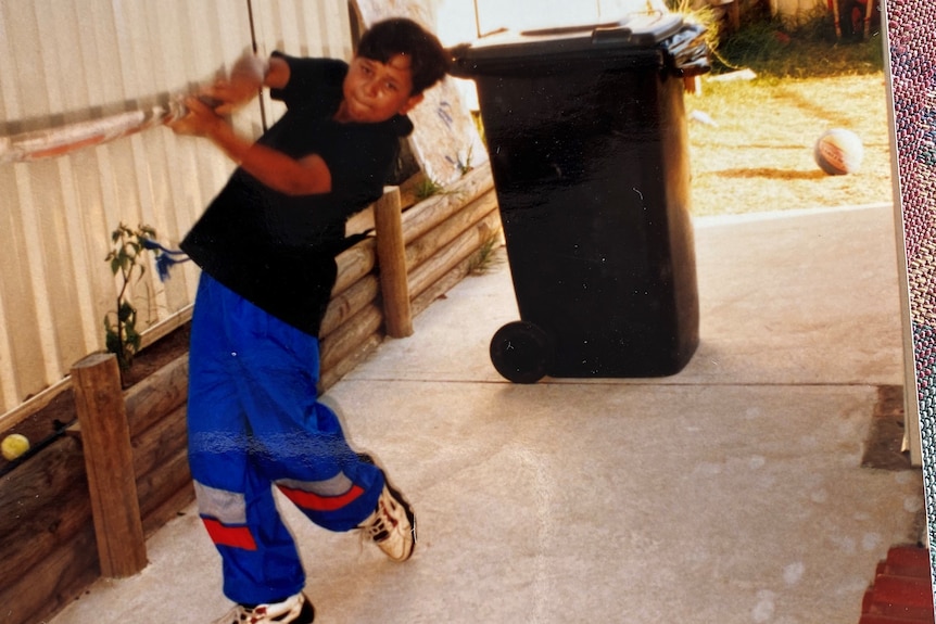 A young Usman Khawaja playing cricket in the backyard