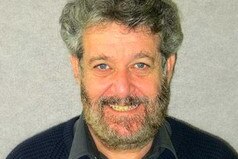 David Beirman, miembro adjunto de gestión y turismo de la Universidad Tecnológica de Sydney, sonriendo con un fondo gris