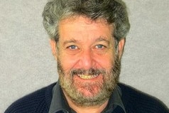 David Beirman, adjunct fellow in management and tourism at Sydney's University of Technology, smiling with grey background