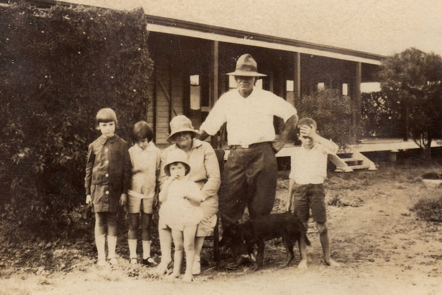 A sepia photograph of the Whitehead story. A well dressed couple in hate, surrounded by four children.