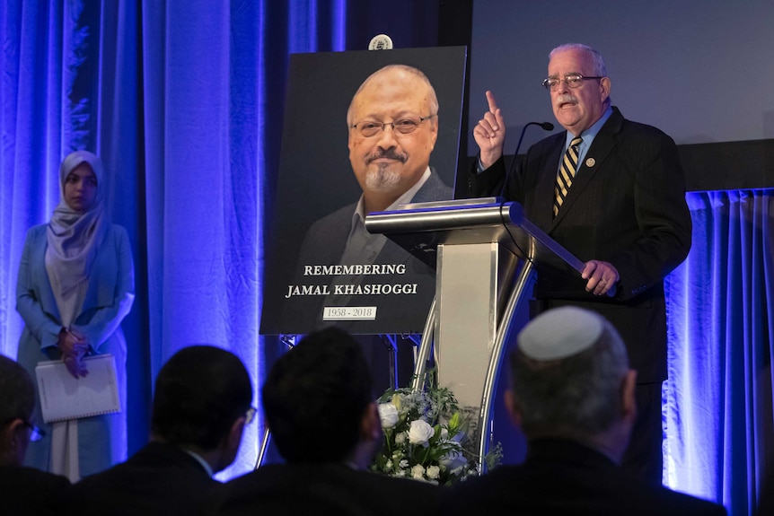 Rep. Gerry Connolly, D-Va stands behind a podium on stage and speaks before a picture of Jamal Khashoggi