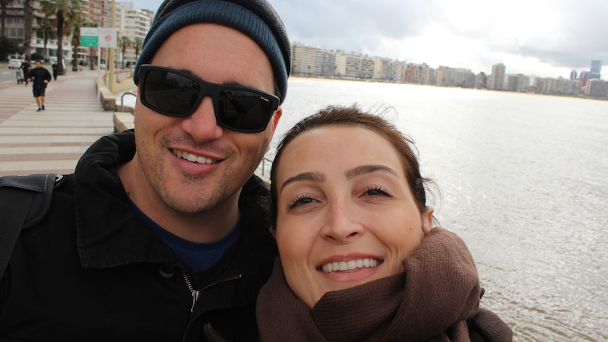 A couple take a selfie near a beach