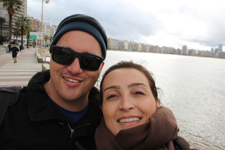 A couple take a selfie near a beach
