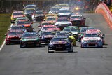The V8 Supercars roar from the start of the Bathurst 1000 at the Mount Panorama Circuit.
