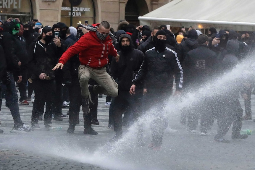 Water is sprayed at demonstrators protesting against COVID-19 health measures in Prague, Czech Republic.