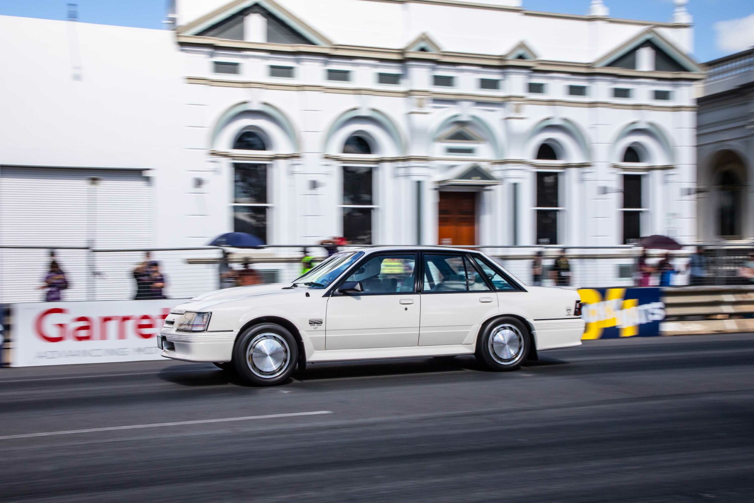 Un coche blanco circula por una pista de carreras.
