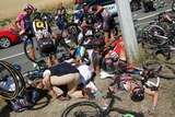 Simon Gerrans (C) and other riders lie on ground after crash on stage three of Tour de France.