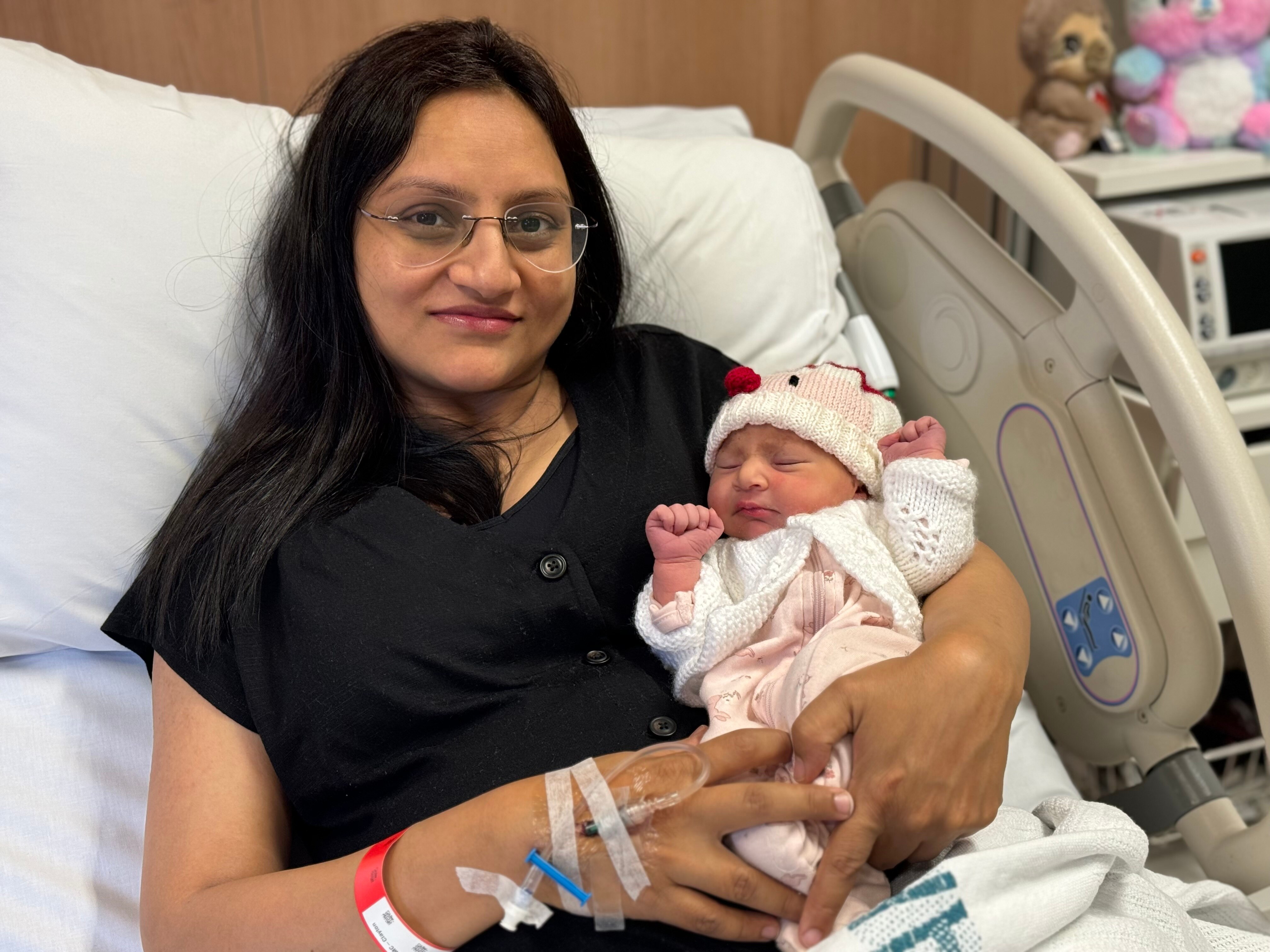 Tulsi Dave holding her baby girl in a hospital bed