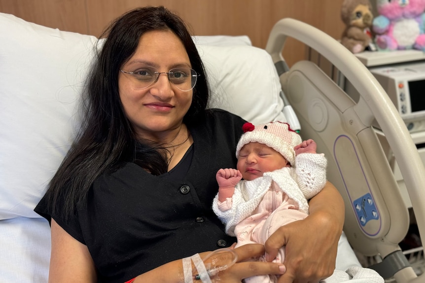 Tulsi Dave holding her baby girl in a hospital bed