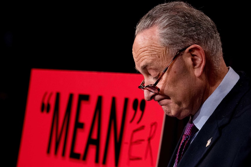 Senate Minority Leader Chuck Schumer, pauses after writing "Mean-er" on a reported quote by President Donald Trump
