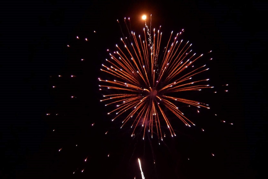 Large orange fireworks explode in the sky over the Mindarie Marina in Perth's north.