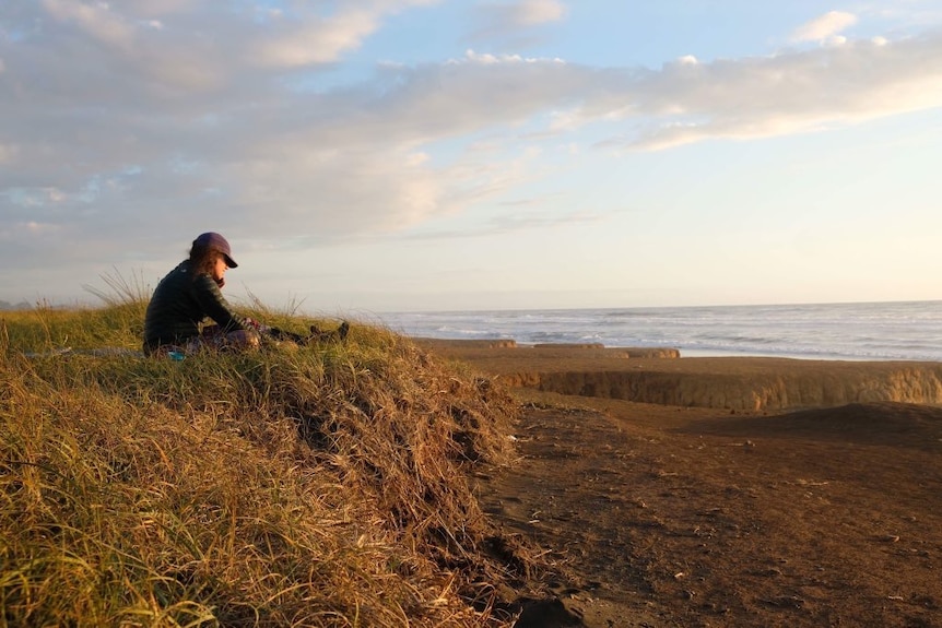 Lucy Barnard sitting on a cliff