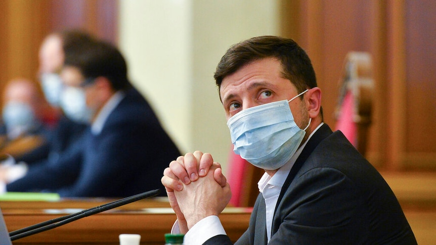 Ukrainian President Volodymyr Zelenskiy wears a face mask to protect against coronavirus during an extraordinary parliamentary.