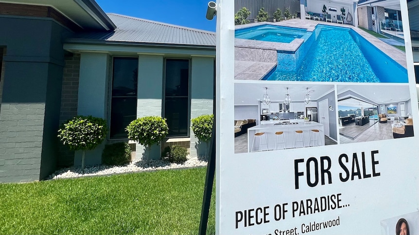 House for sale with a sign that says "piece of paradise".