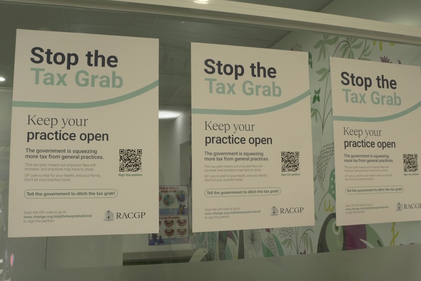 Three posters are stuck on a window saying "stop the tax grab", "keep your practice open" and other information.