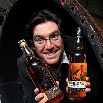 Greg Ramsay holding two bottles of whisky