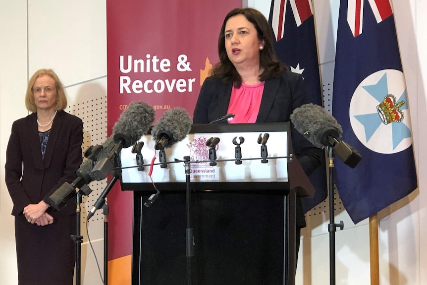 Premier Annastacia Palaszczuk speaks as the Chief Heath Officer looks on