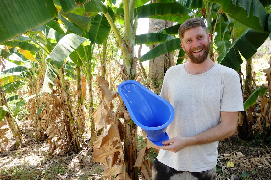 Who Gives a Crap co-founder and chief executive Simon Griffiths holding a plastic portable toilet bowl.