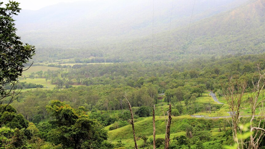 A panoramic view looking down to a green valley.