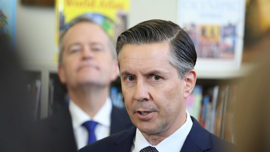 Mr Butler talks at a press conference while Bill Shorten looks on from behind