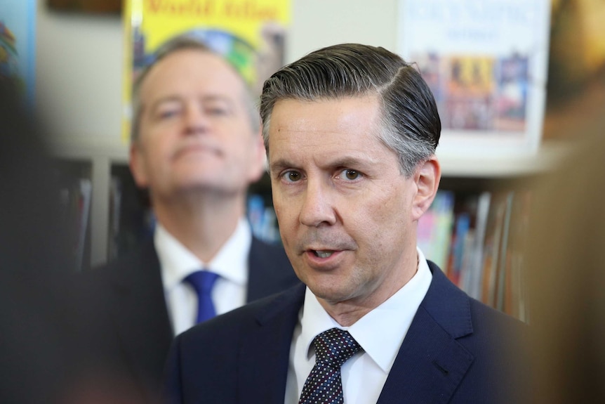 Mr Butler talks at a press conference while Bill Shorten looks on from behind