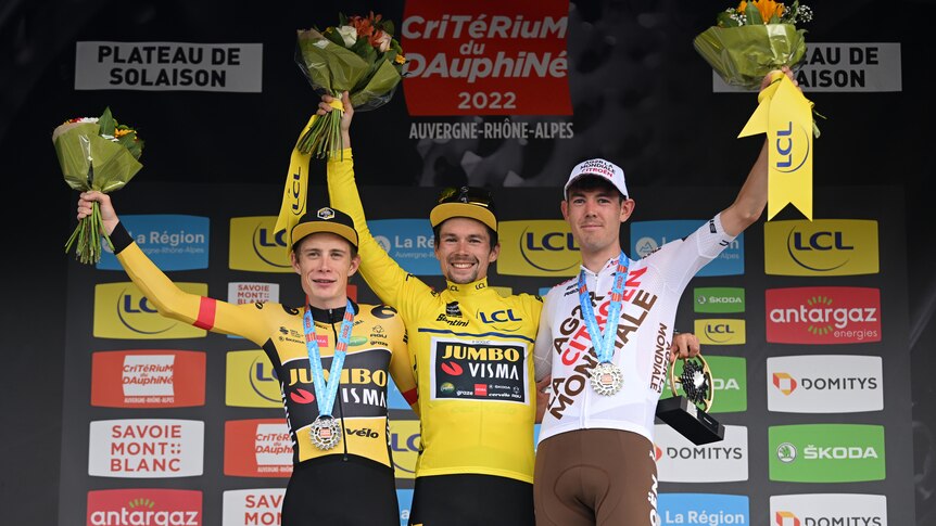 The top three riders stand on the podium at the end of a stage race, with Australia's Ben O'Connor in third.