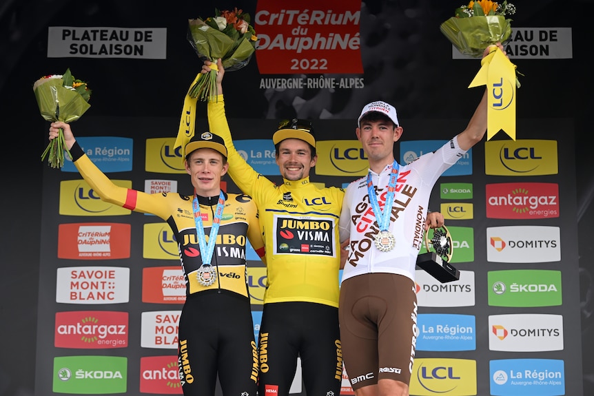 The top three riders stand on the podium at the end of a stage race, with Australia's Ben O'Connor in third.