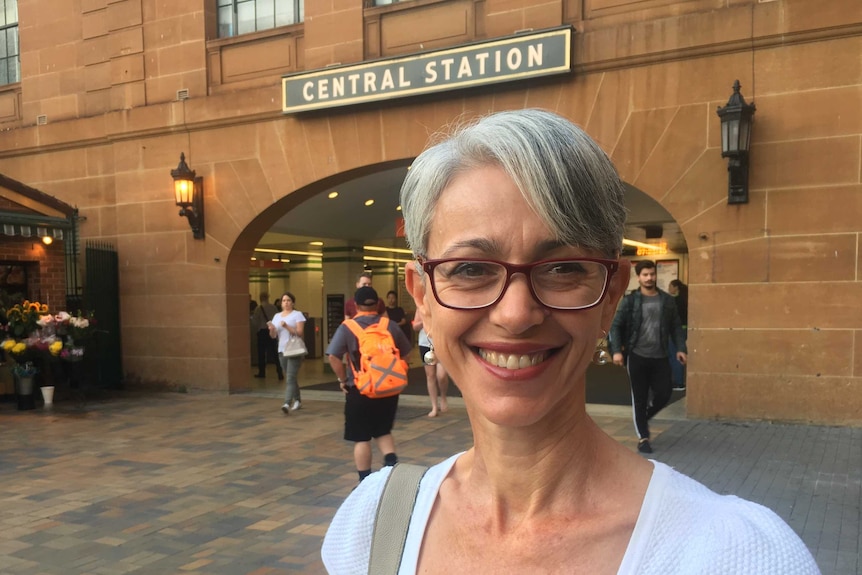 Woman with short white hair and glasses smiling