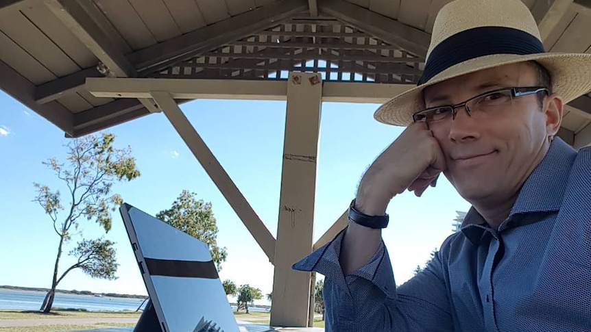 man in hat sitting in front of computer