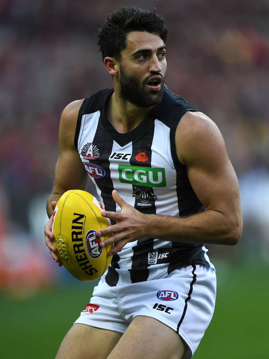 Alex Fasolo holds the football while playing against Essendon at the MCG.