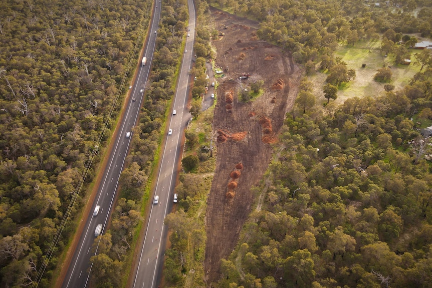 A drone shot of a highway with land bulldozed next to it