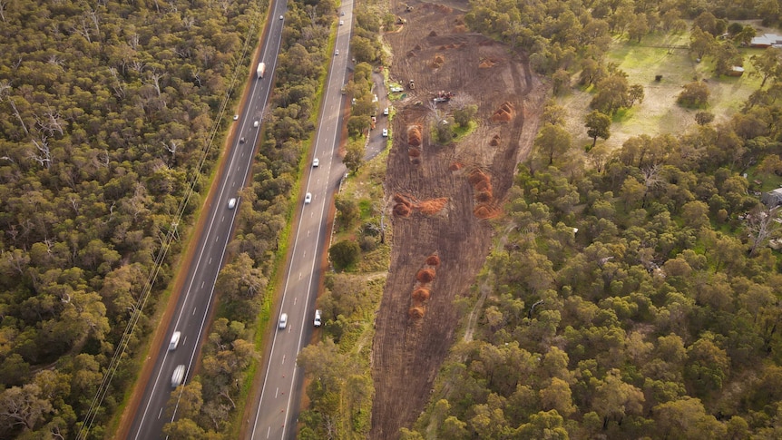 A drone shot of a highway with land bulldozed next to it