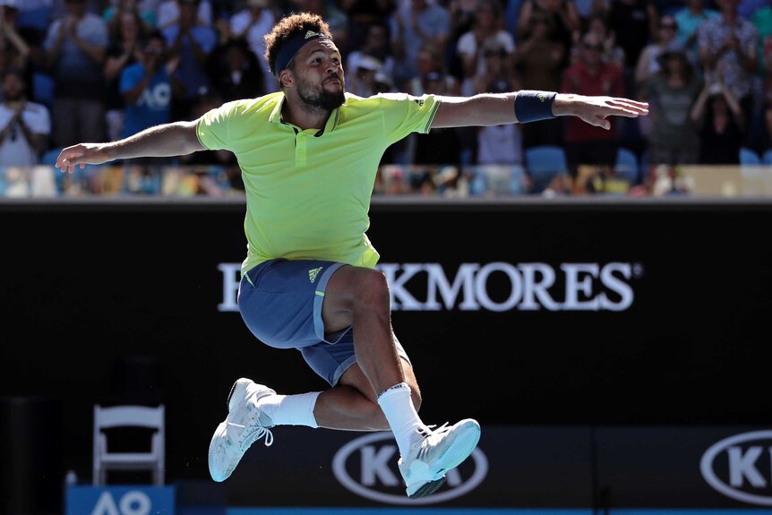 Jo-Wilfried Tsonga jumps in the air to celebrate his win over Denis Shapovalov at the Australian Open.