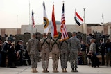 The US and Iraqi national flags are seen before they are carried in during ceremonies marking the end of US military mission