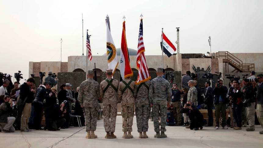 The US and Iraqi national flags are seen before they are carried in during ceremonies marking the end of US military mission