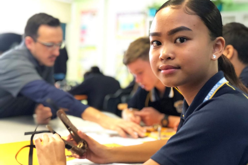 Year 8 student Georgia Angat sits at a desk in a classroom at Mabel Park State High School.