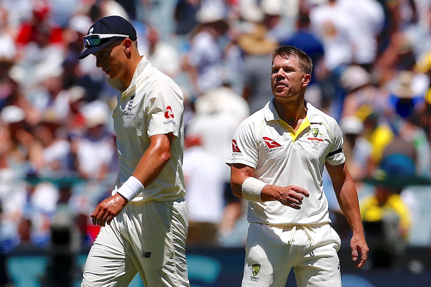 David Warner speaks at England's Tom Curran, wearing a cap during a Test match.