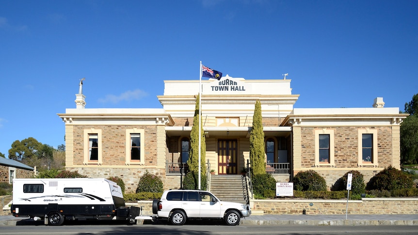 A 4WD towing a caravan parked in front of the Burra Town Hall