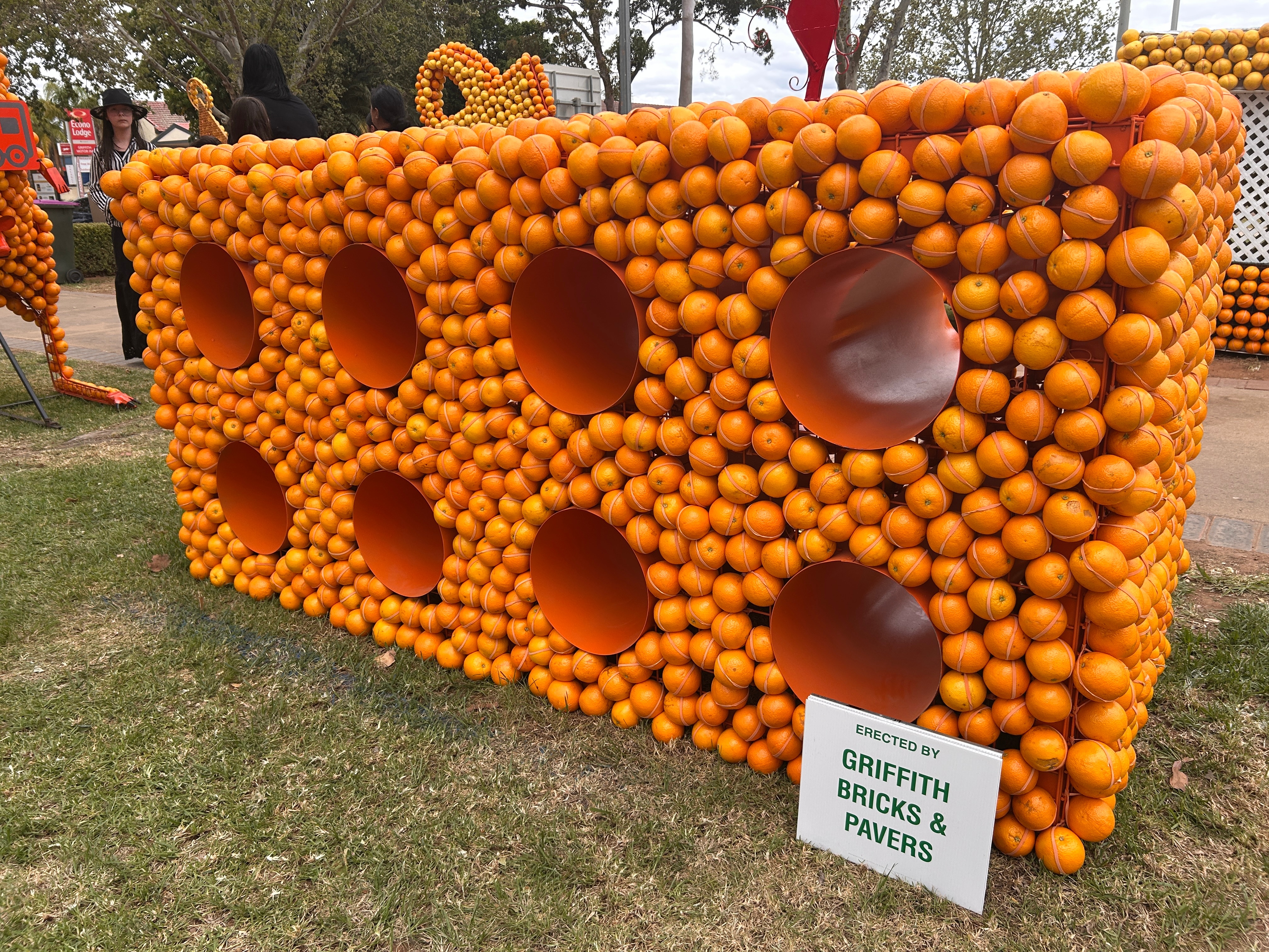 A sculpture of a giant brick, made out of oranges.
