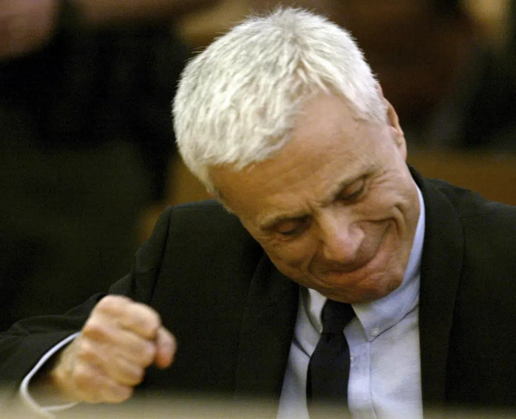 A photo of Robert Blake wearing a suit and sitting inside a courtroom 