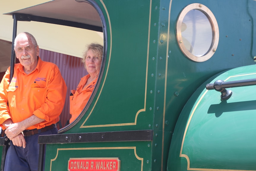 Bob and Judy standing side by side in bright orange inside the Peckett locomotive 