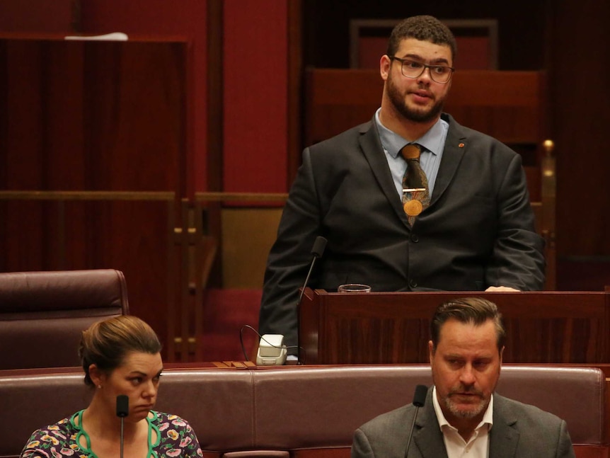 Jordon Steele-John frowns in his spot in the Senate, with Peter Whish-Wilson and Sarah Hanson-Young sitting in front.