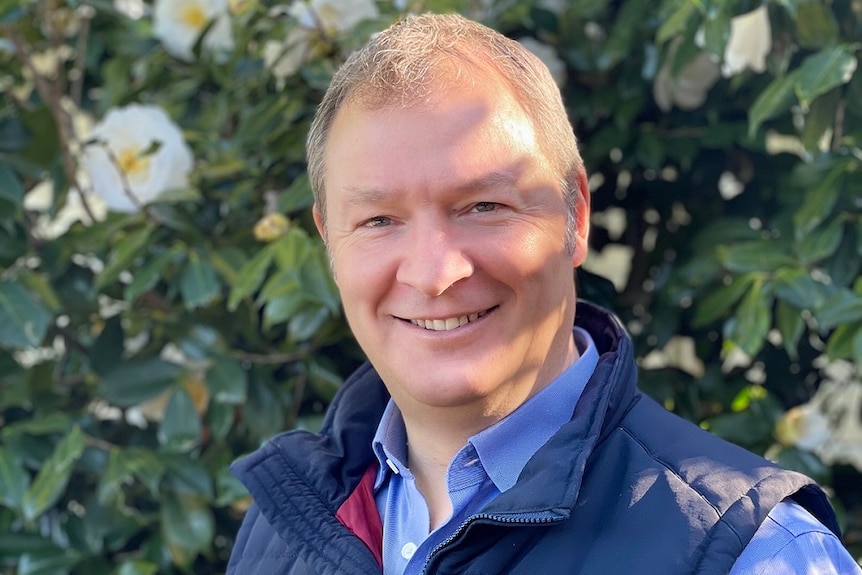 Eden Brew CEO Jim Fader standing in front of a bush