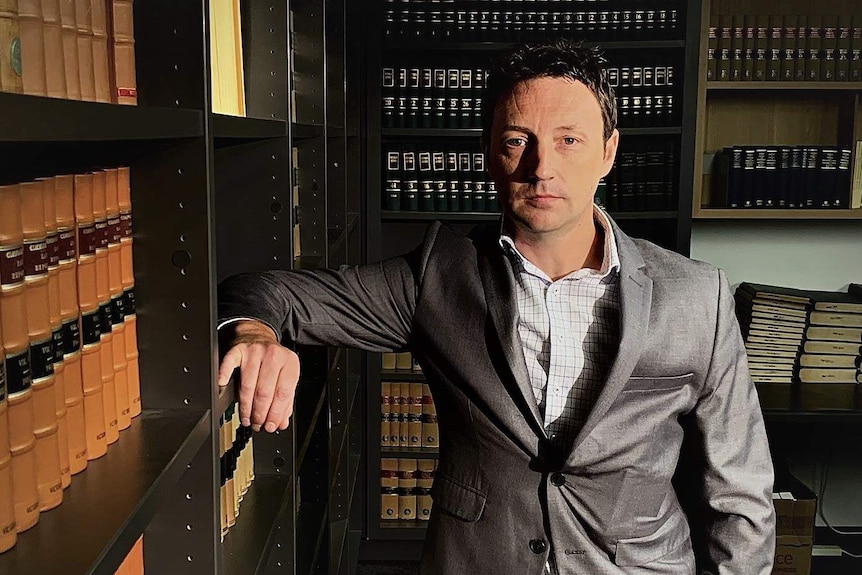 Lawyer Roman Fida stands in a law library.